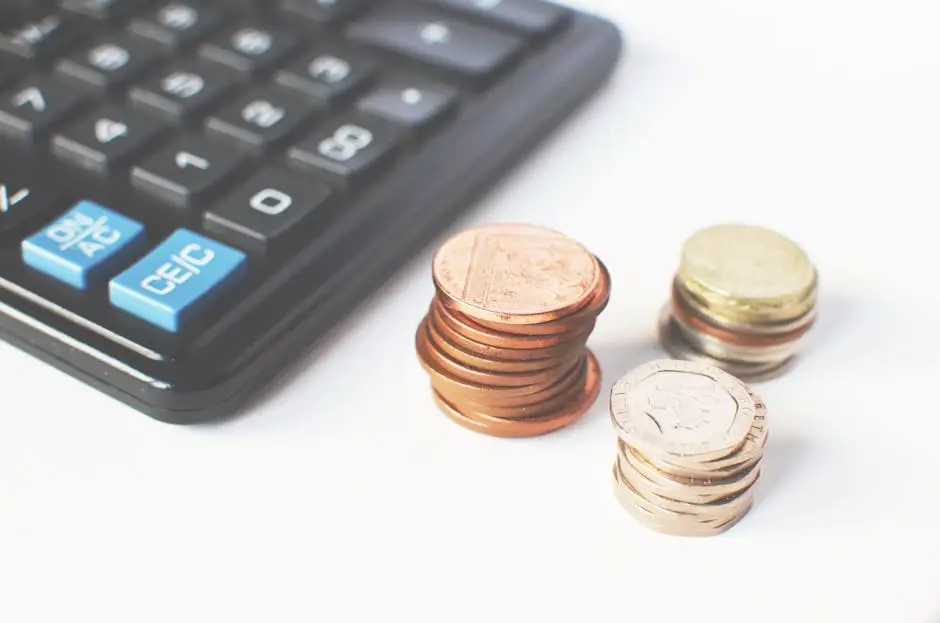 Home Close-up of stacked coins and a calculator symbolizing financial strategy and budgeting.